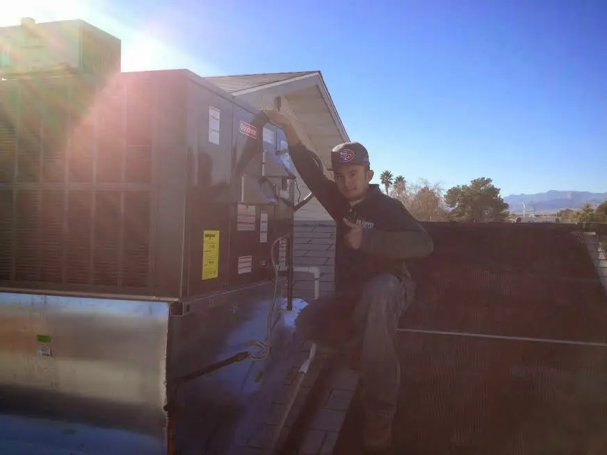 HVAC technician performing AC Tune-Up on a rooftop unit in Saugus